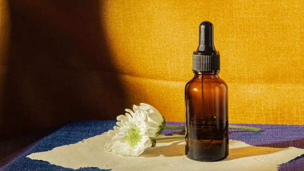 Close-up of a woman applying hair serum to her hair