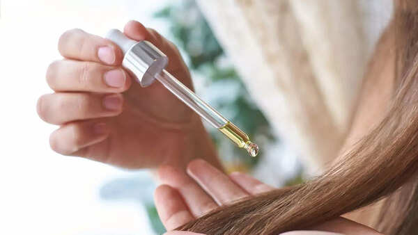 Woman's hands applying hair serum to her freshly washed hair