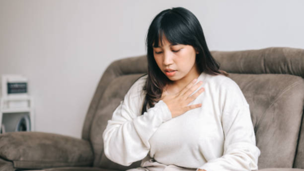 Woman struggling to breathe, a symptom that could indicate heart problems.
