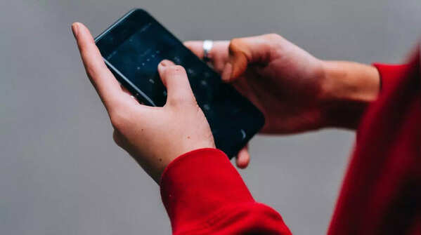 Person holding phone with both hands and thumbs
